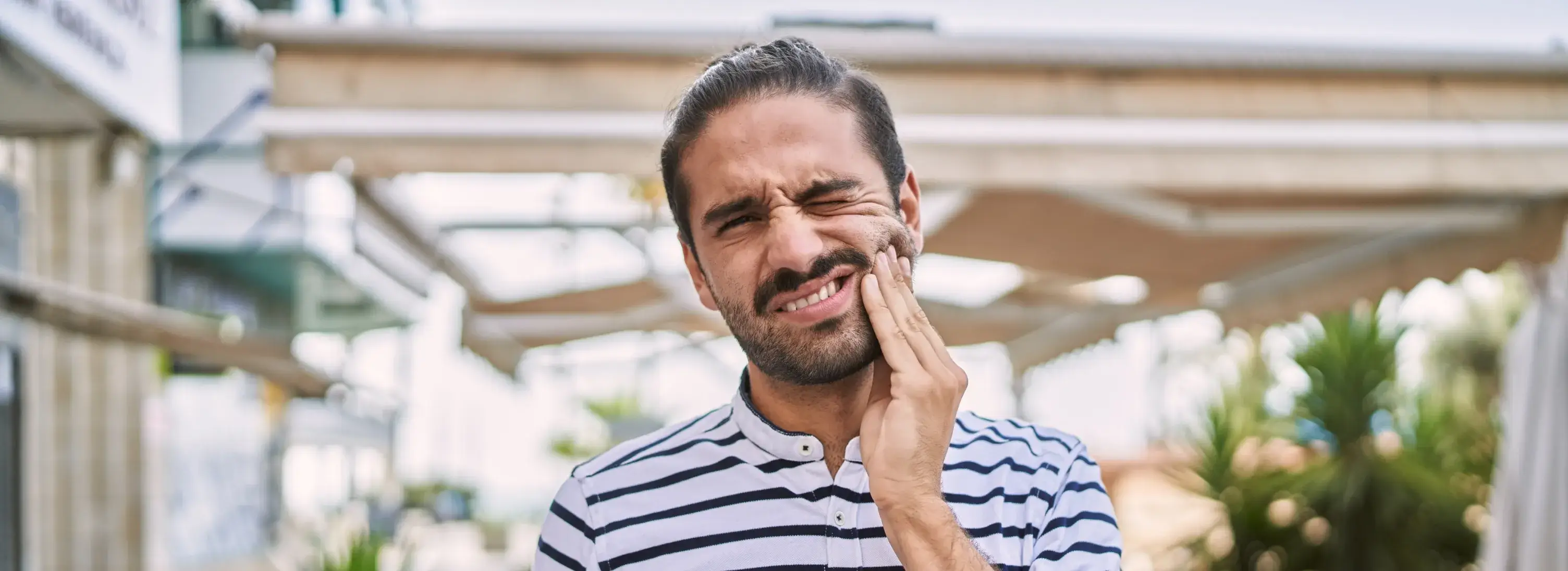 A man holding his hand to his face.