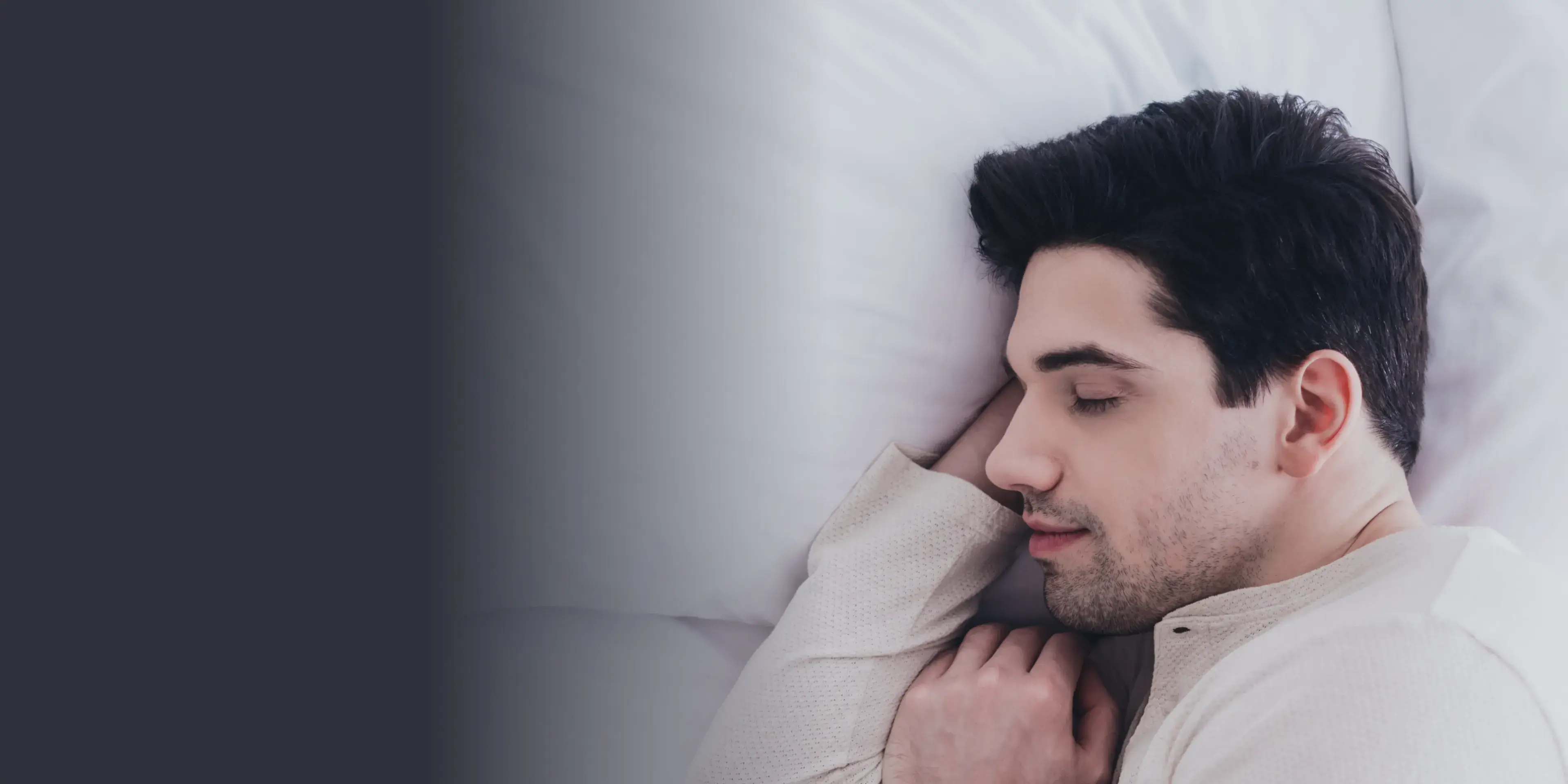A man laying in bed with his head on his hand.