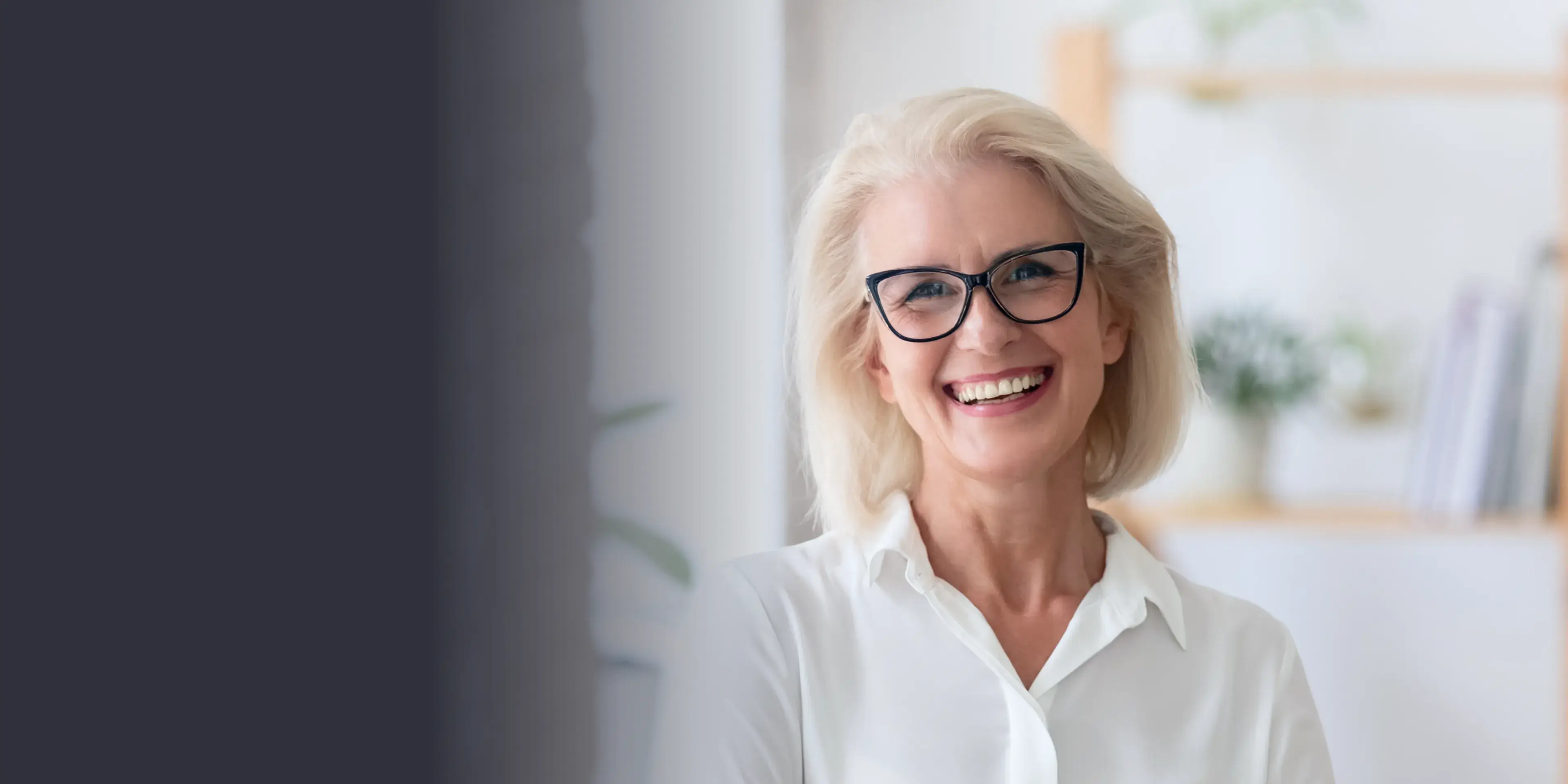 A woman with glasses smiling at the camera.