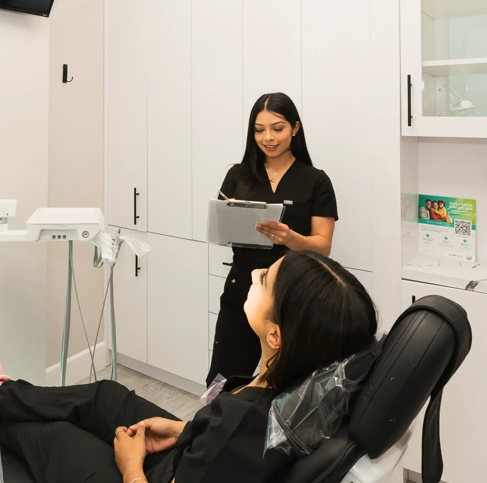 A woman sitting in a chair in a dentist's office.