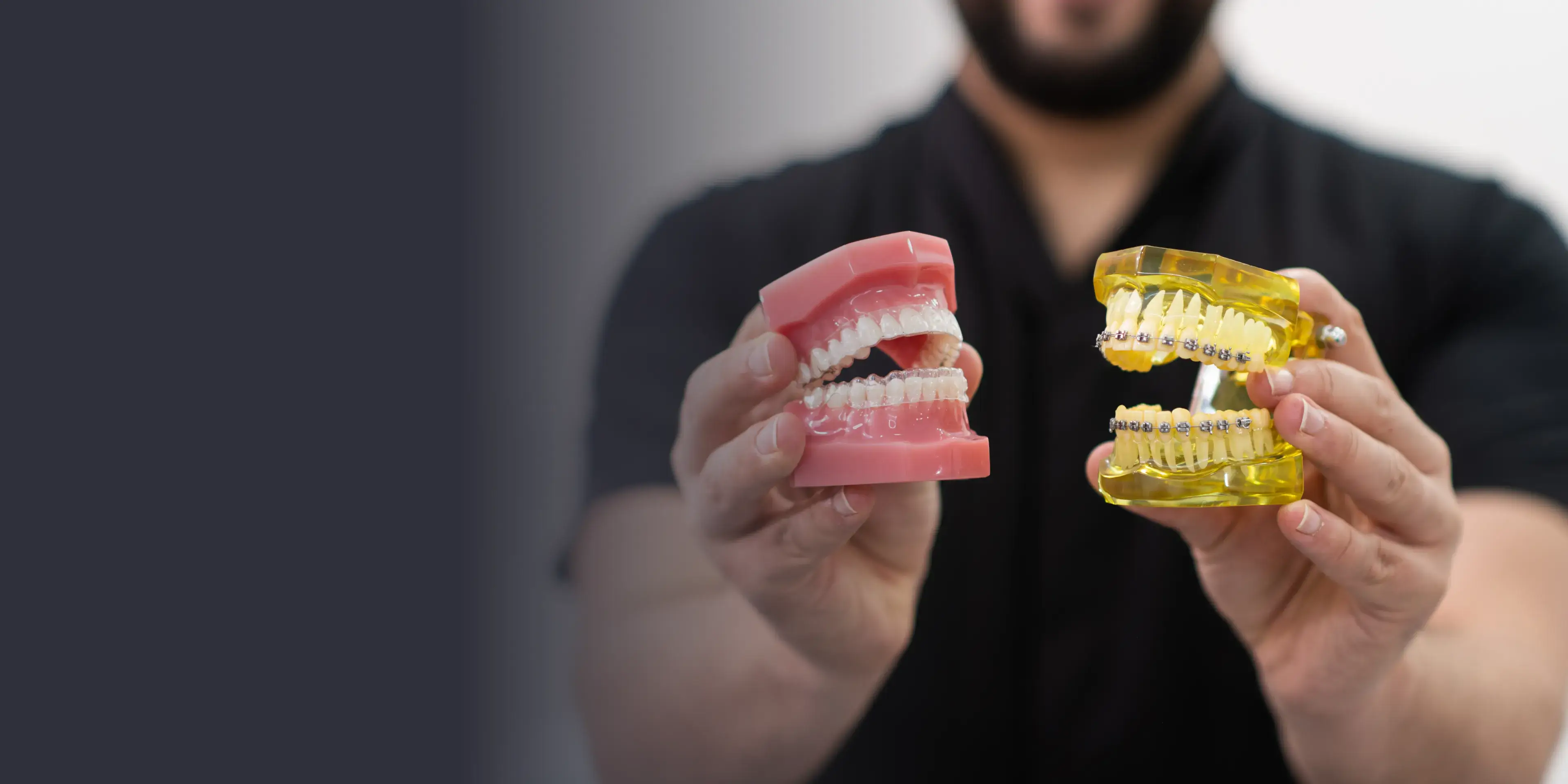 A man holding a model of a tooth and a gum.