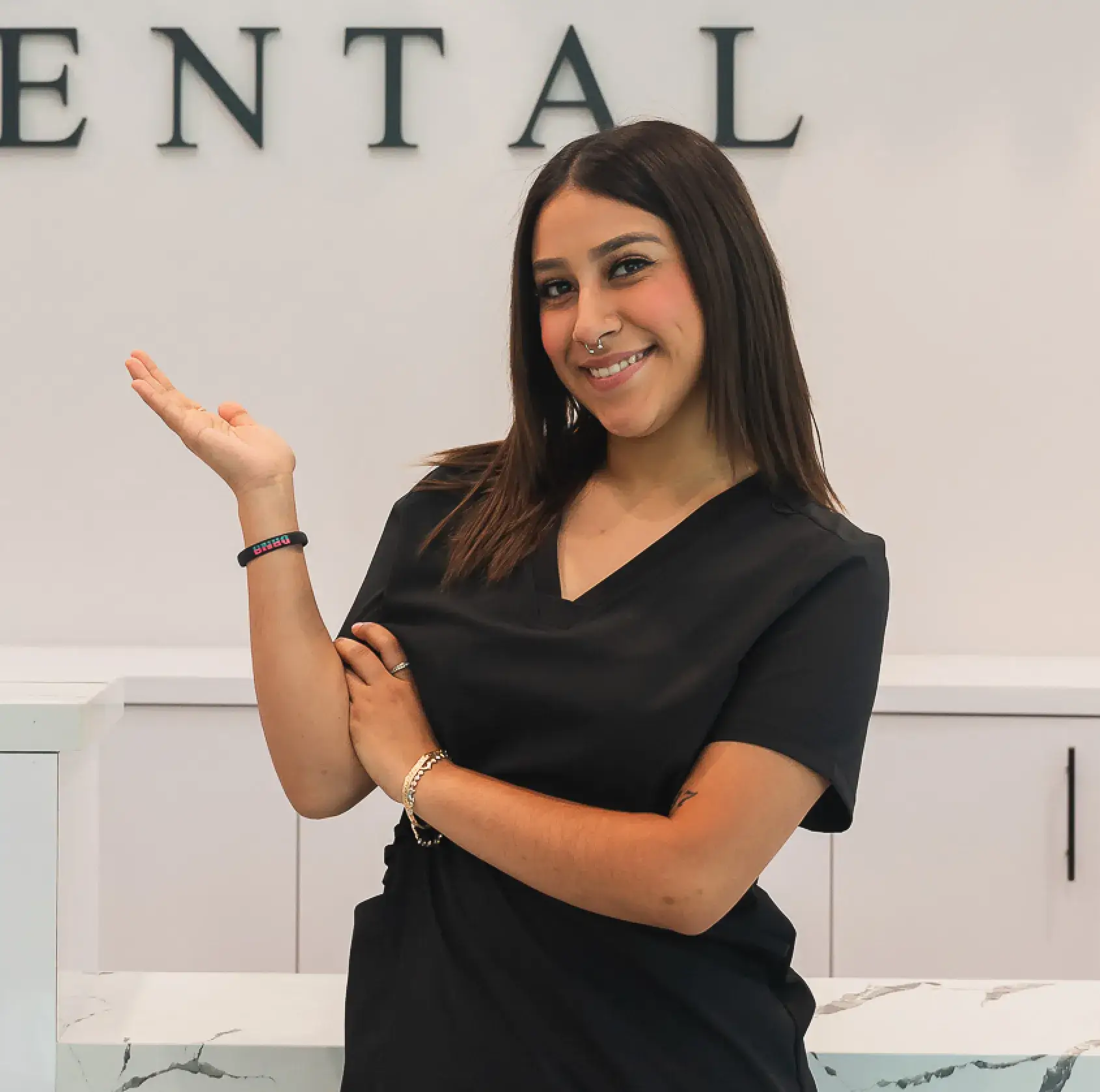 A woman standing in front of a dental sign.