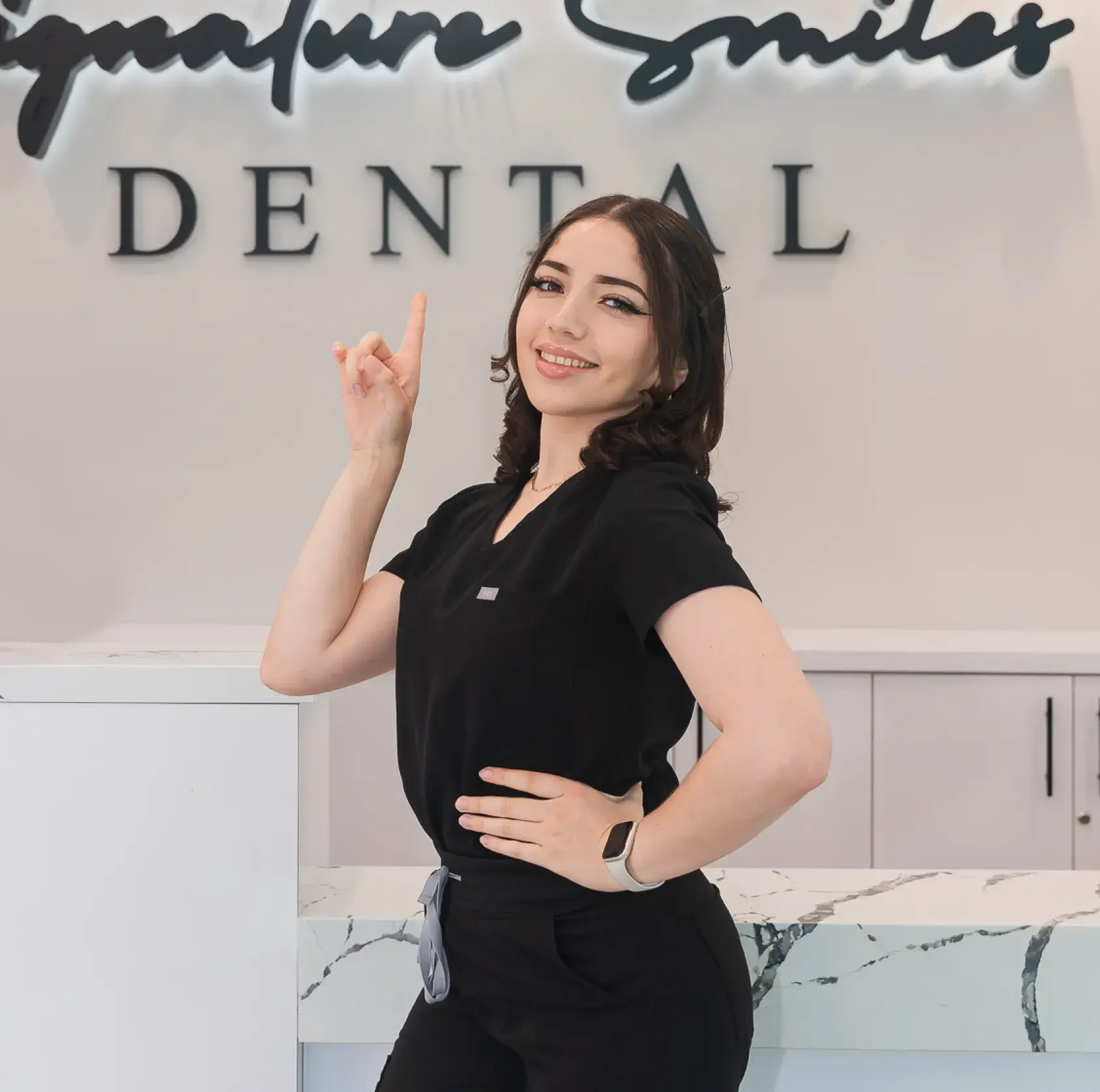 A woman standing in front of a dental sign.