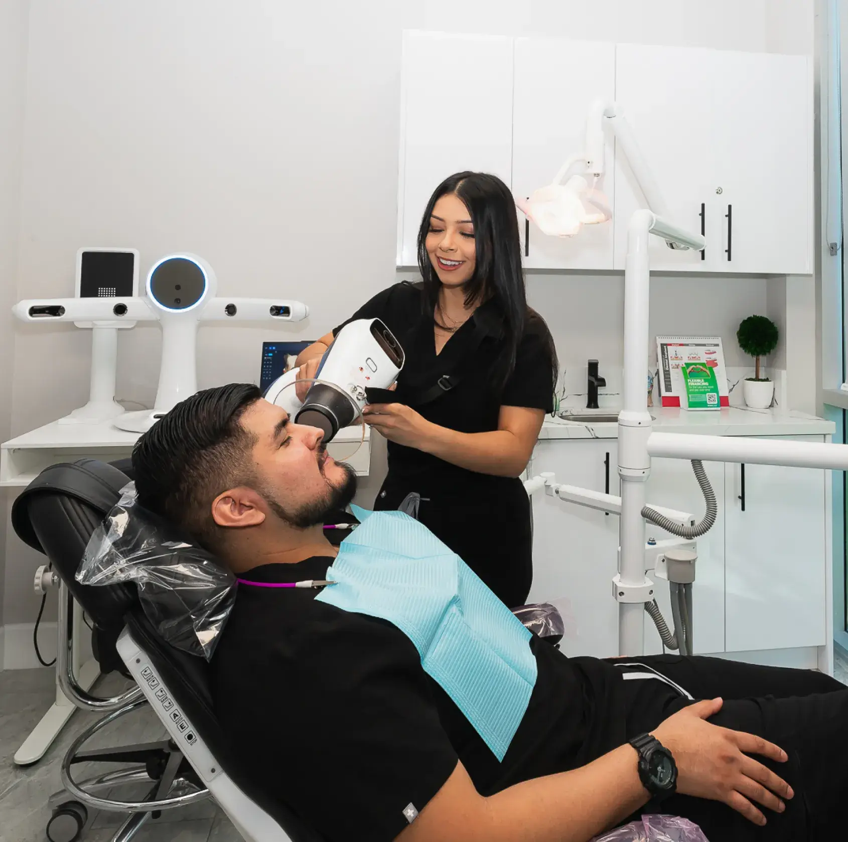 A man getting his teeth brushed by a dentist.