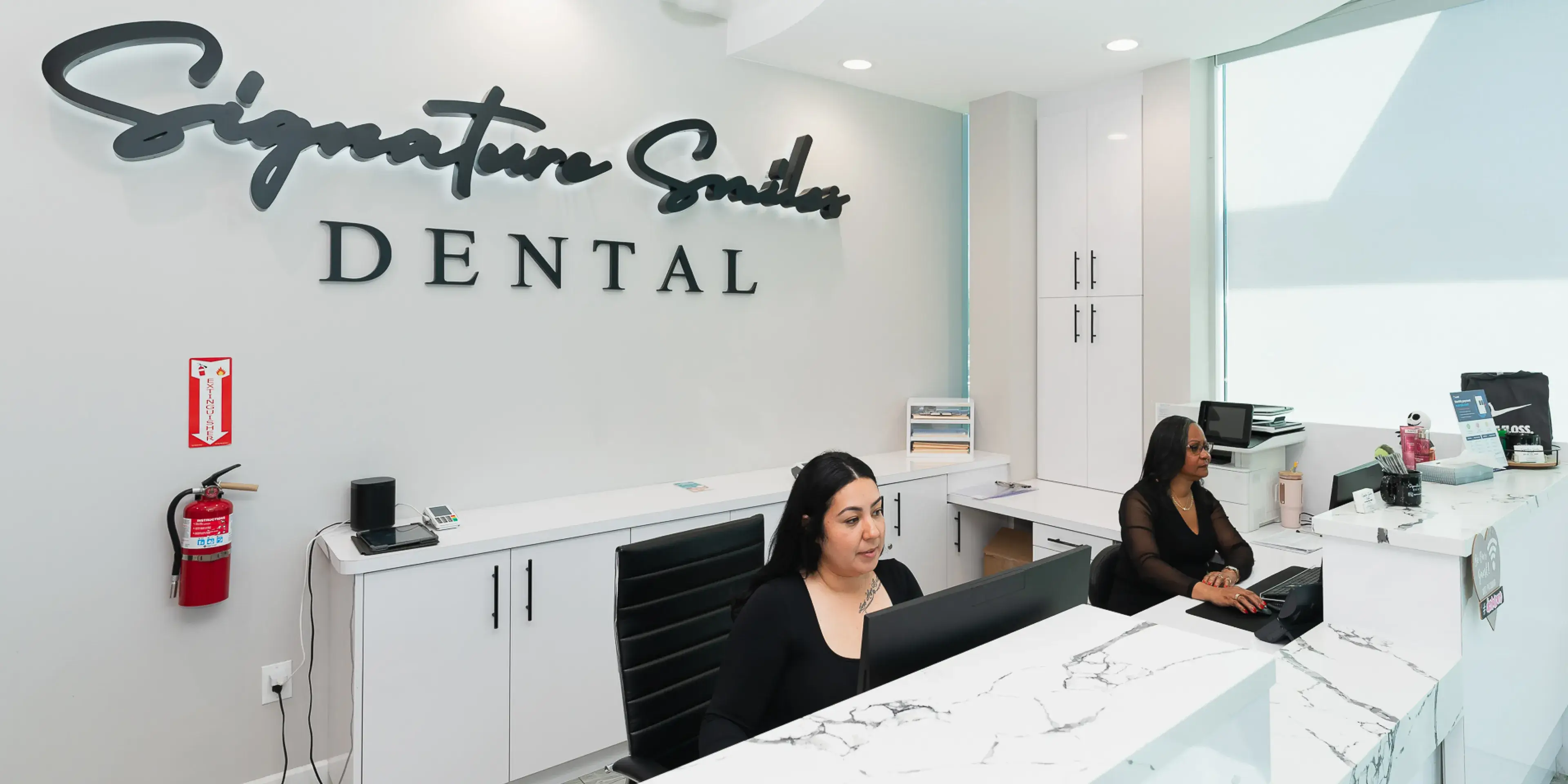 A woman sitting at a desk in a dental office.