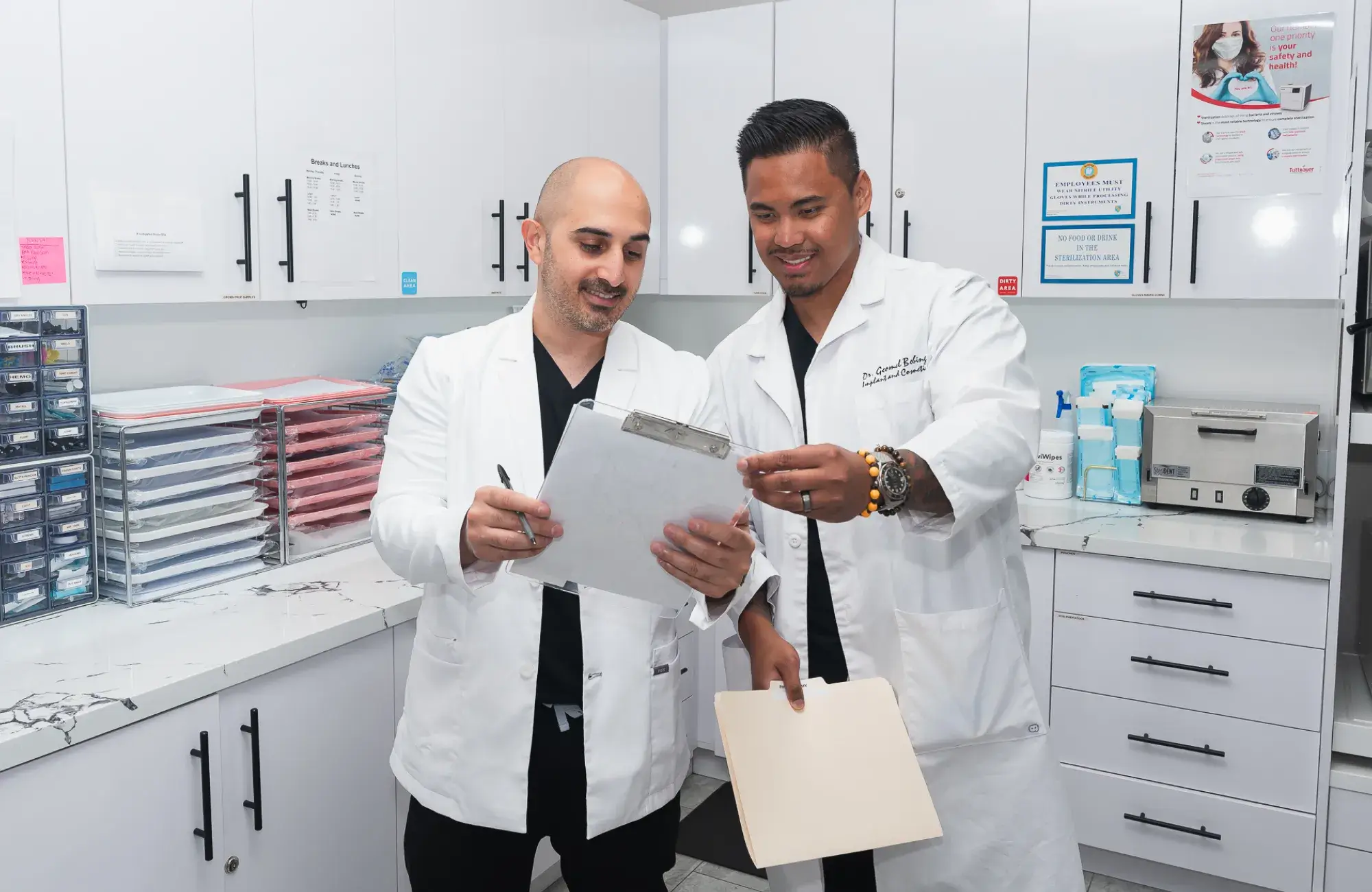 Two men in lab coats looking at a piece of paper.