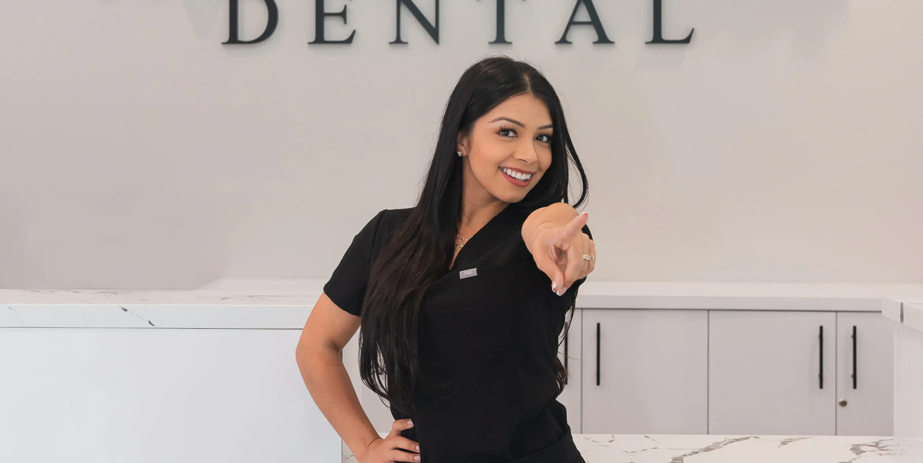A woman standing in front of a dental office.