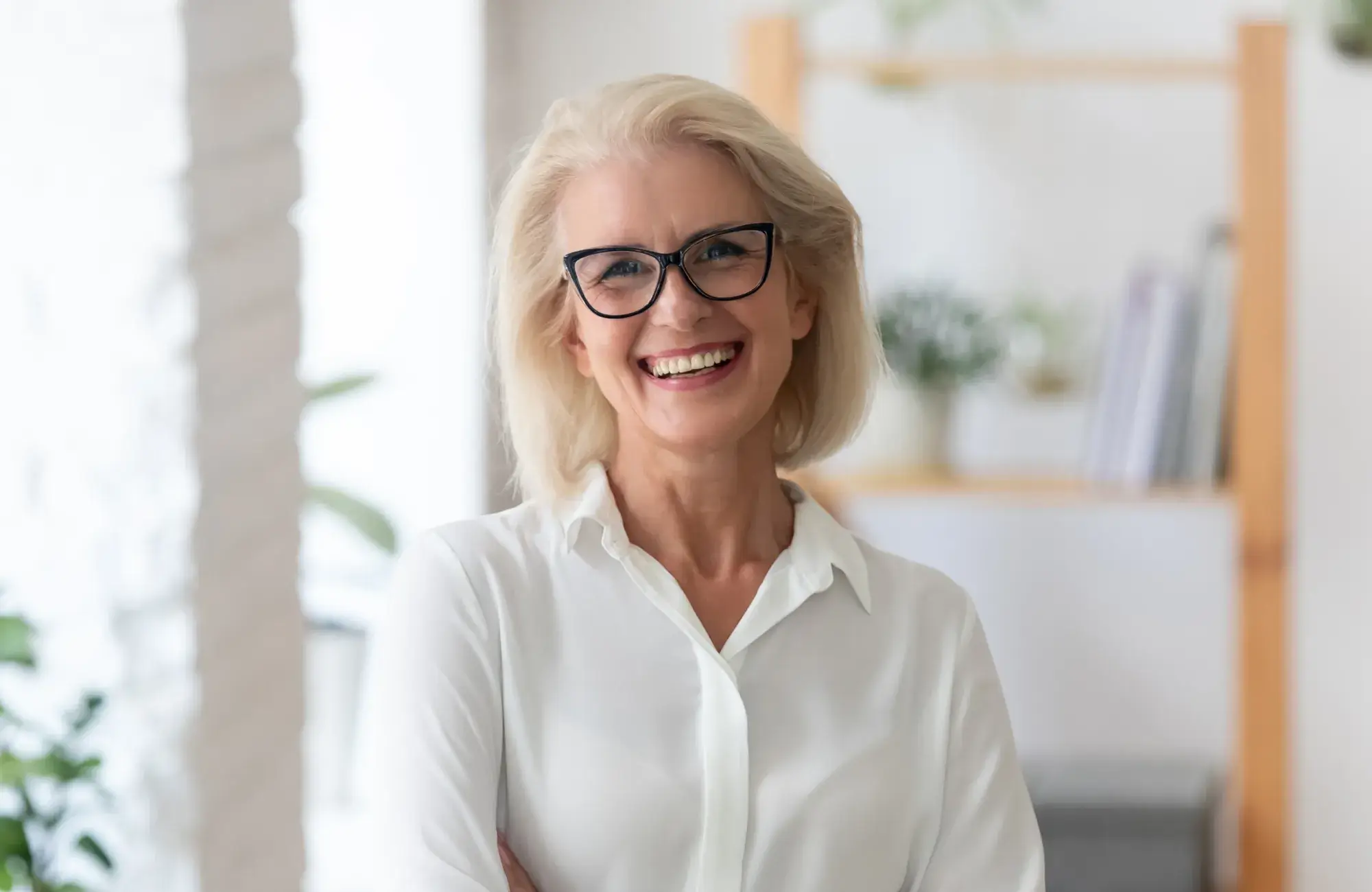 A woman with glasses is smiling for the camera.