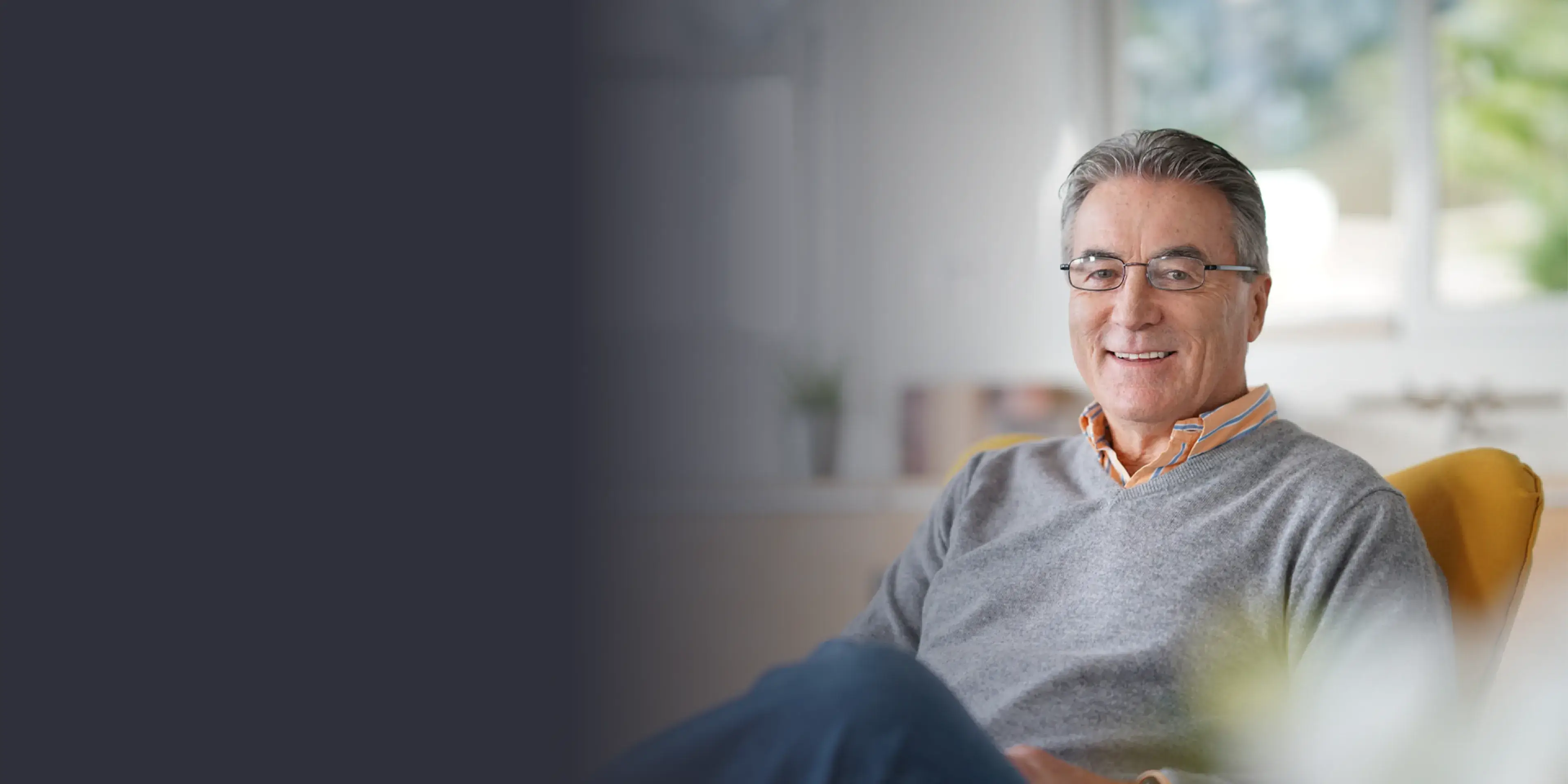 A man sitting in a chair smiling at the camera.