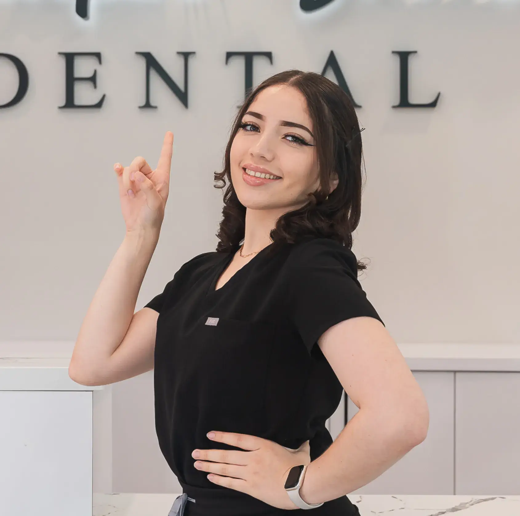 A woman standing in front of a dental sign.