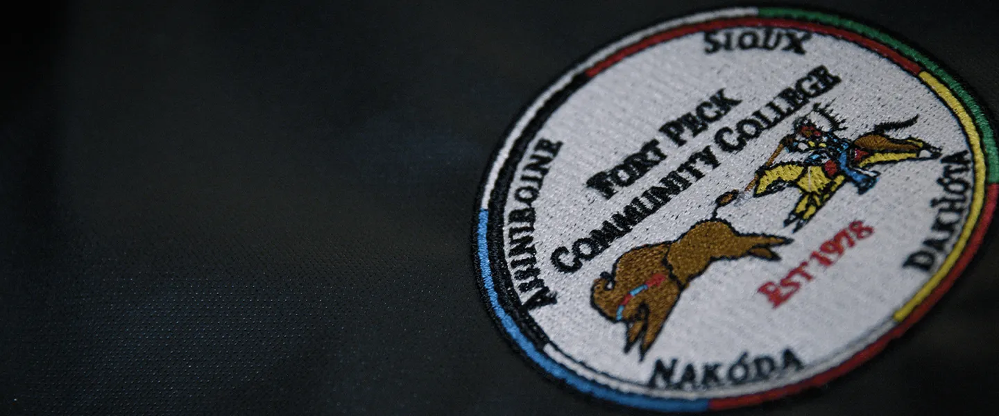Close-up of the official Fort Peck Community College emblem stitched on fabric, symbolizing tribal heritage, academic pride, and the institution’s legacy.