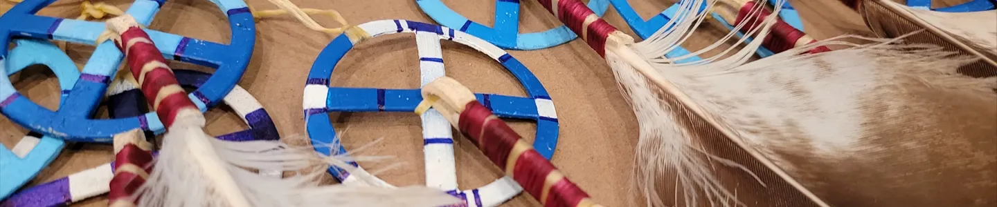 Close-up of handmade Native American crafts featuring colorful medicine wheels and feathers, reflecting cultural education at FPCC.