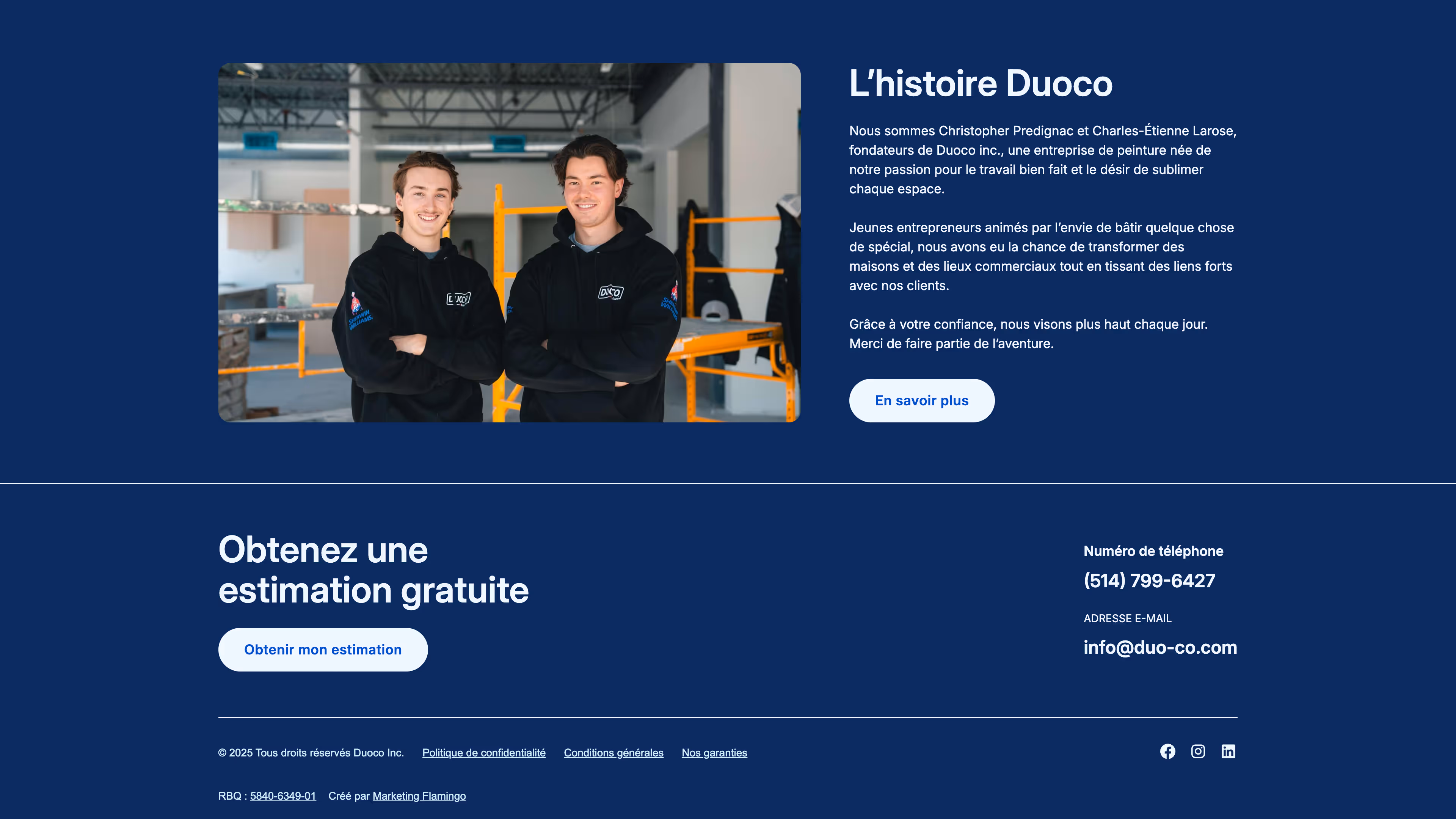 Two young men in black Duoco hoodies standing with arms crossed inside a warehouse with orange scaffolding in the background.