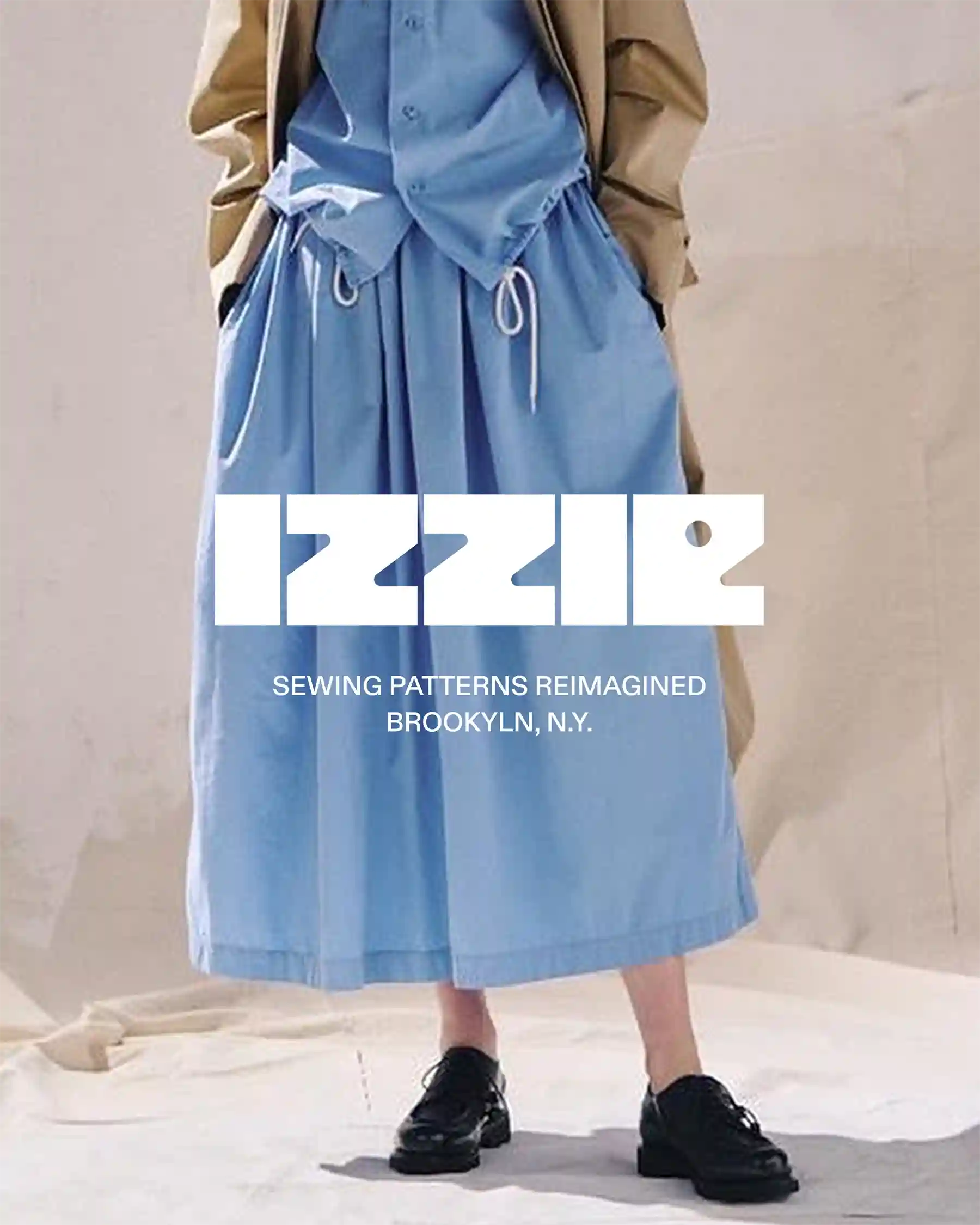 Model in blue shirt and skirt set with Izzie logo overlay — tagline “Sewing Patterns Reimagined, Brooklyn NY”
