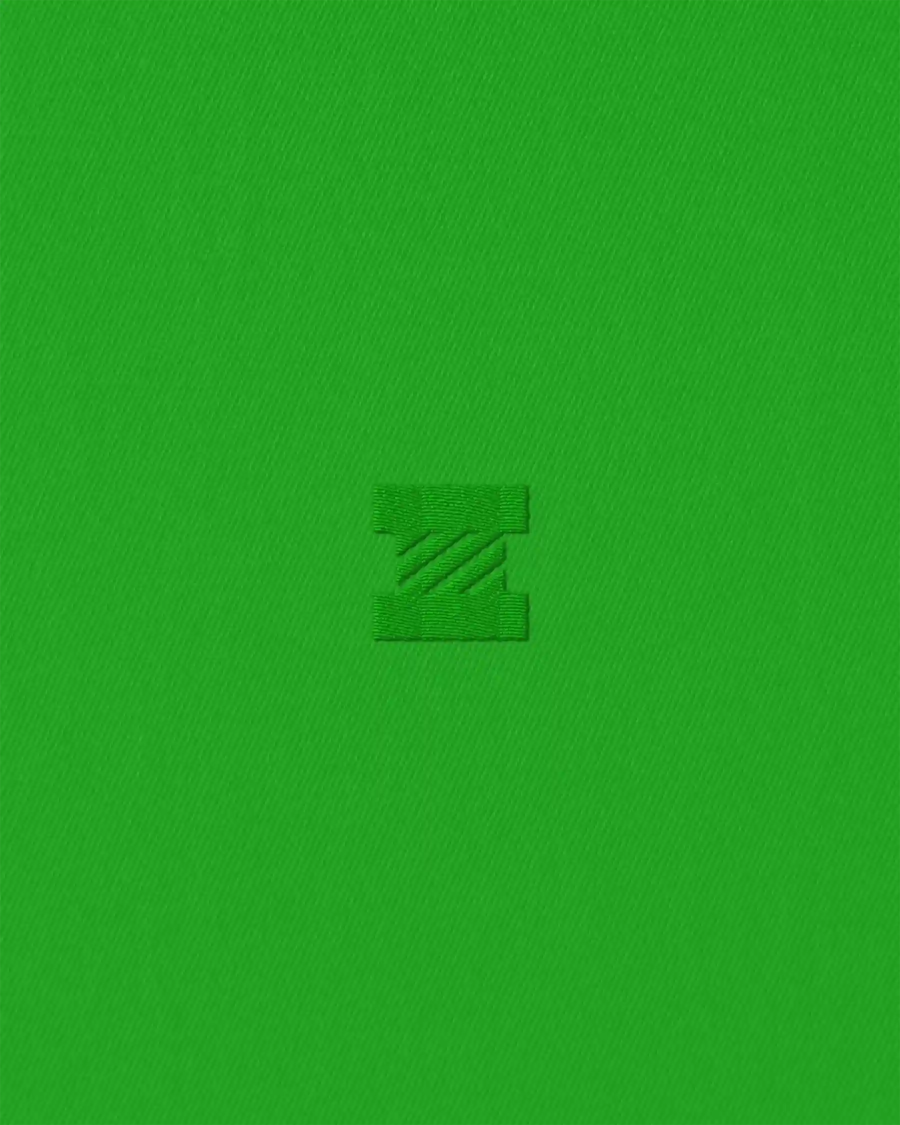 Close-up of green fabric with embroidered Izzie “Z” monogram