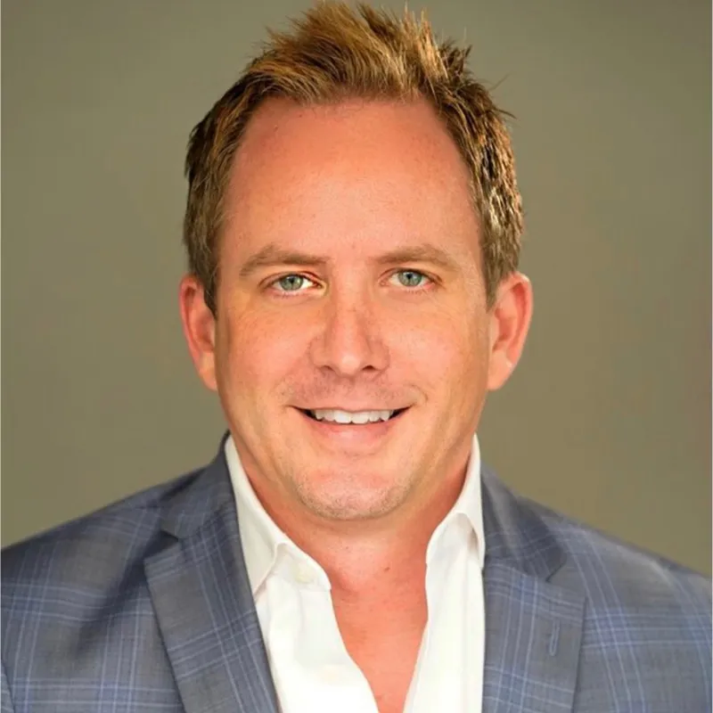 A man in a suit smiling for a picture.