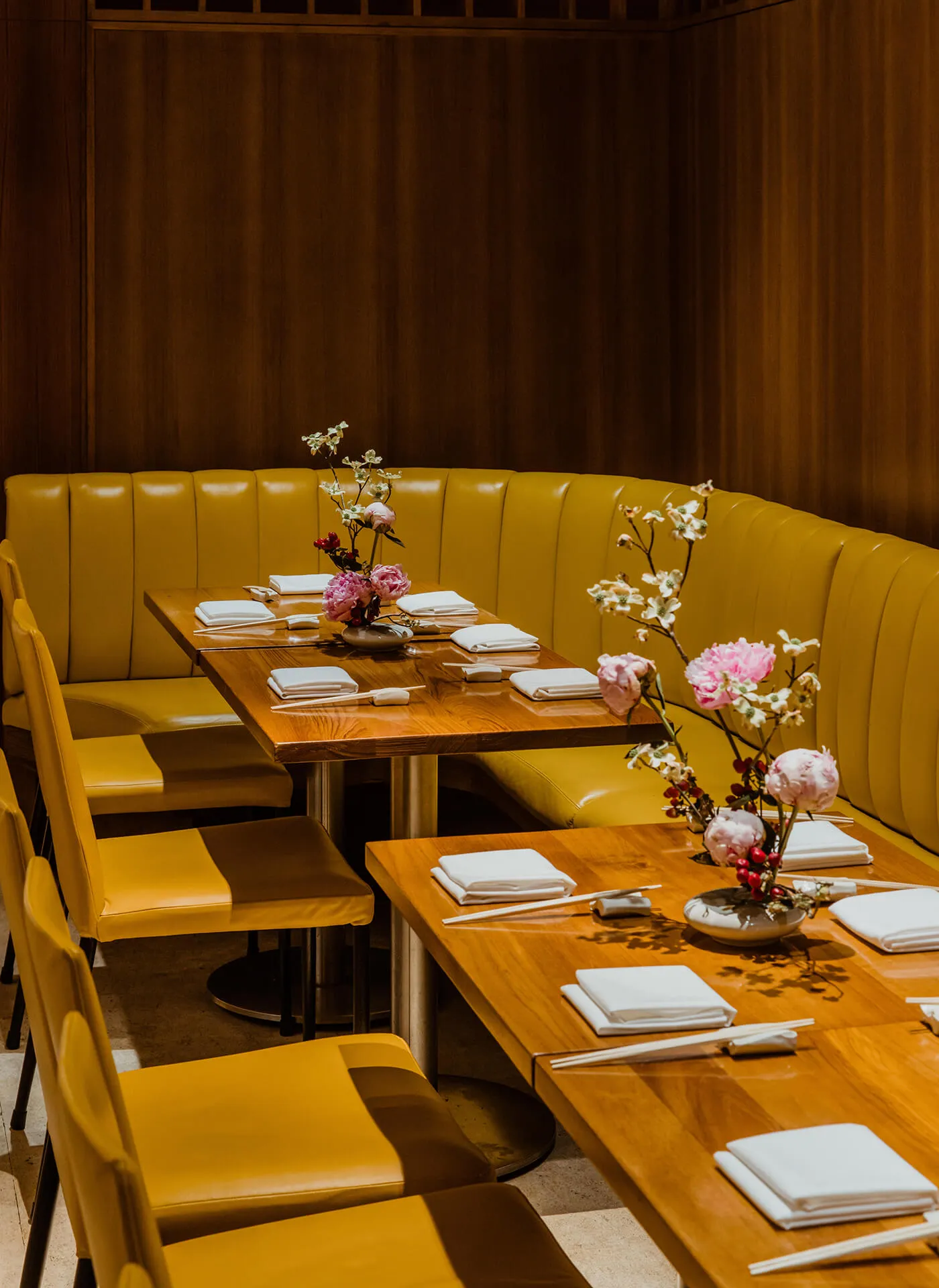 Booth seating at Kappo Masa featuring place settings and flower arrangements.