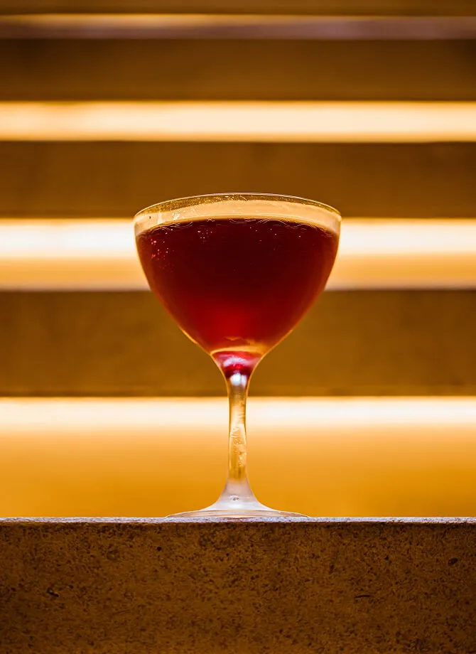 A cinematic shot of a cocktail resting on the steps at Kappo Masa