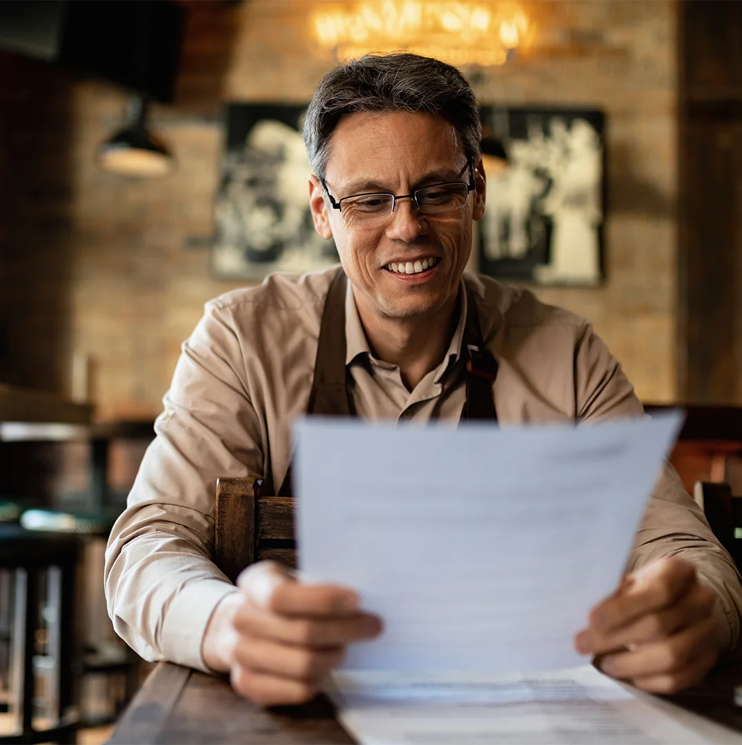 Man looking at a piece of paper and feeling satisfied