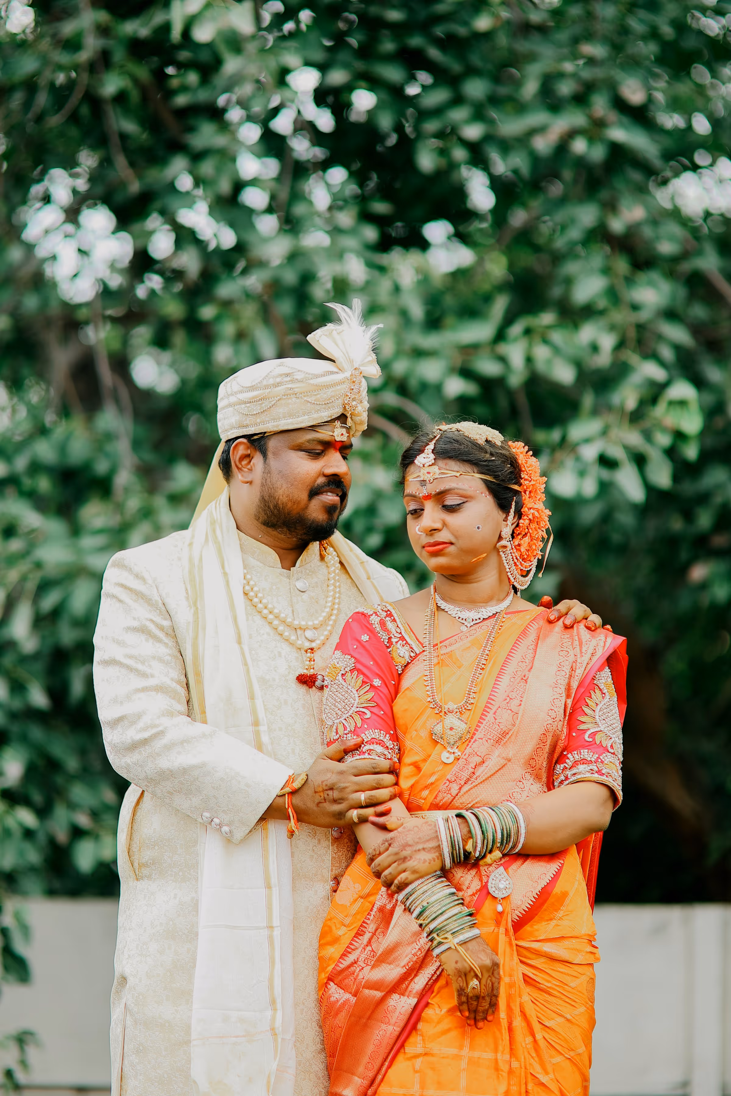 Couple dressed in traditional white and orange wedding garments during outdoor ceremony — cinematic moment from a cross-cultural wedding film.