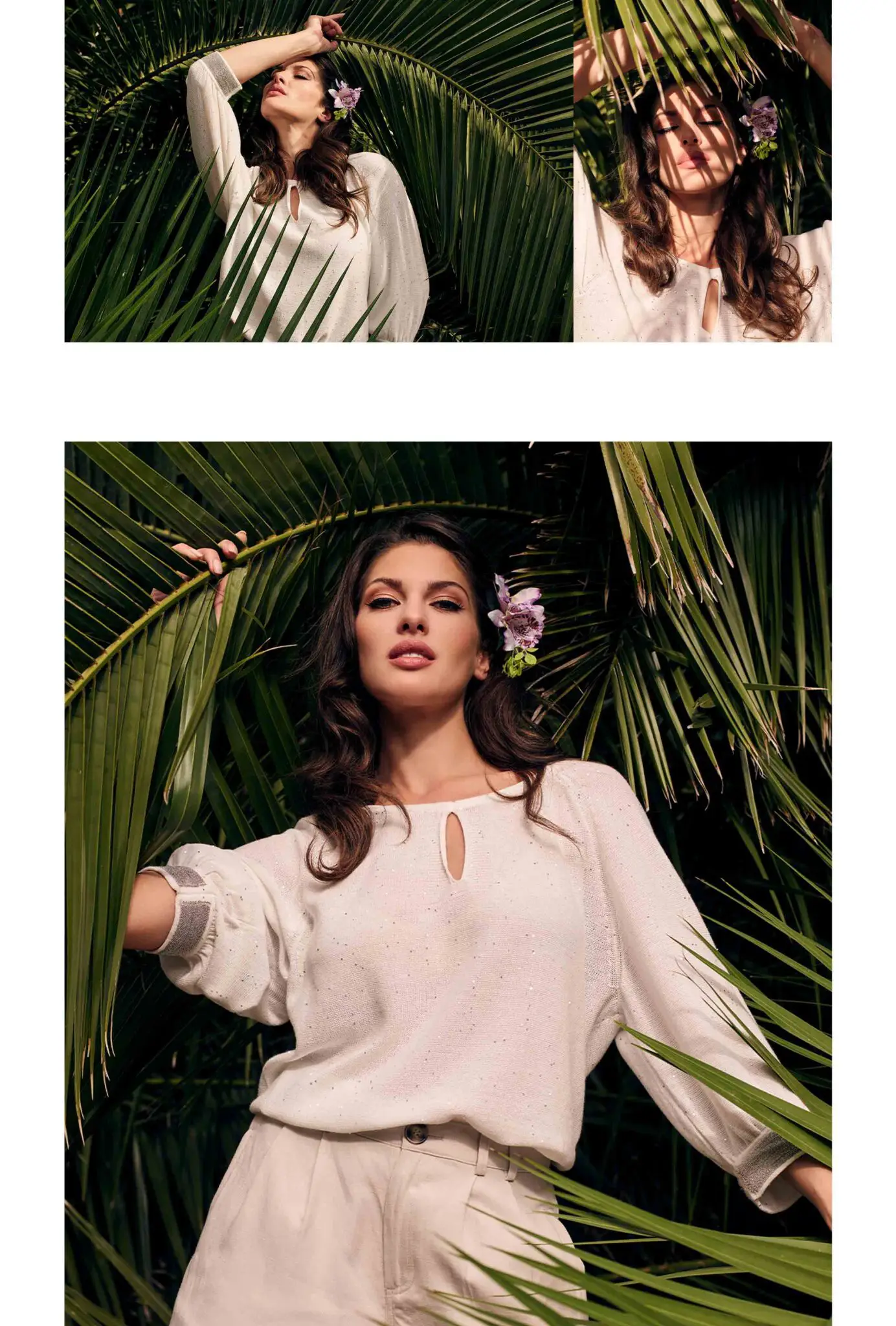 Woman wearing a white blouse and beige pants posing among green palm leaves with a purple flower in her hair.