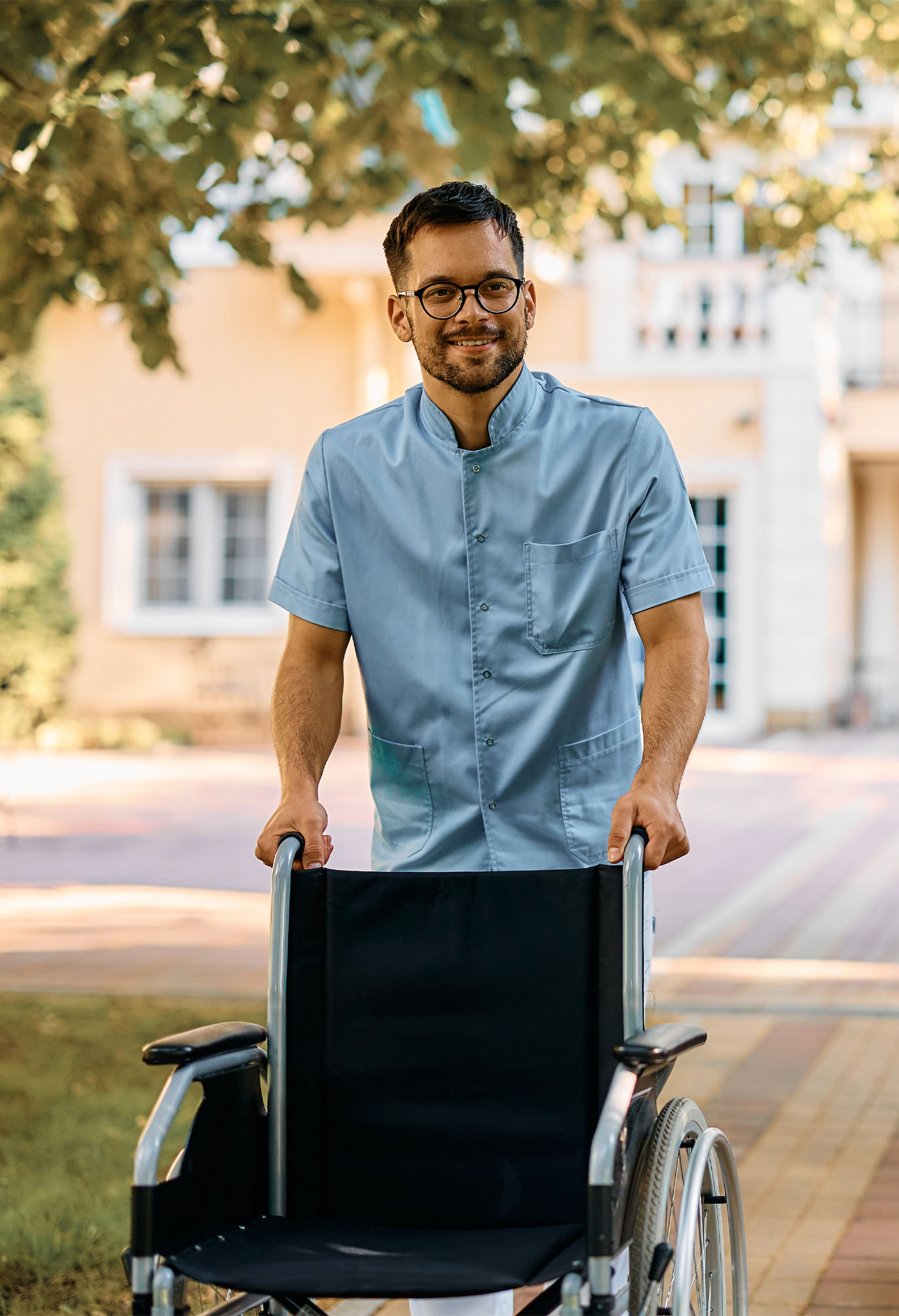 Eine Alltagshilfe die einen Rollstuhl schiebt.