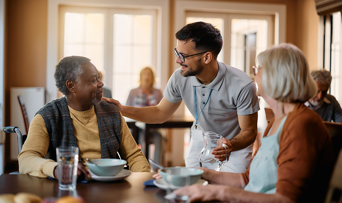 Alltagshilfe die zwei Senioren Essen serviert.