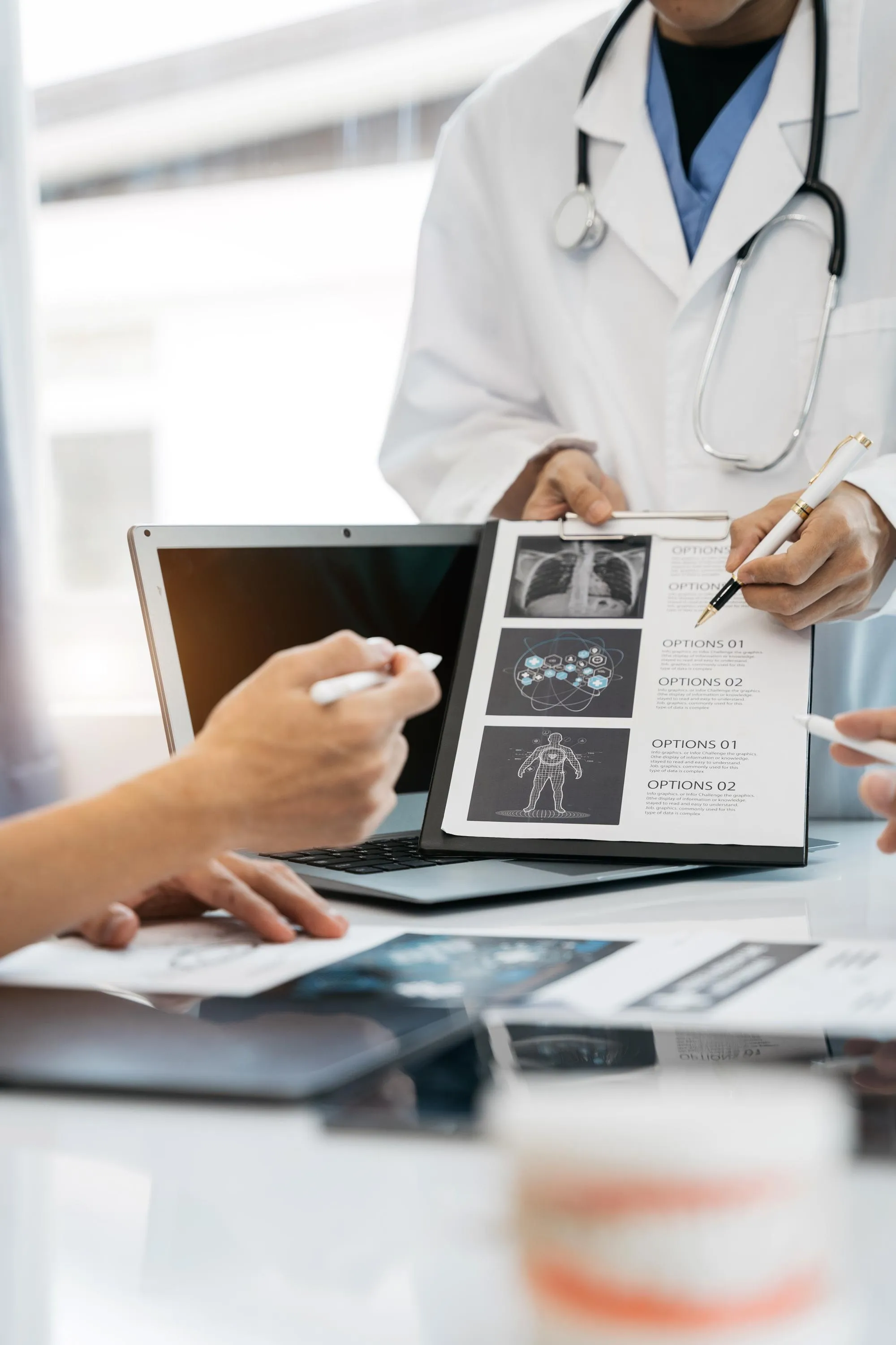 Dentist reviewing digital dental X-rays on a laptop with a patient while discussing diagnosis and personalized treatment plans in a modern clinic