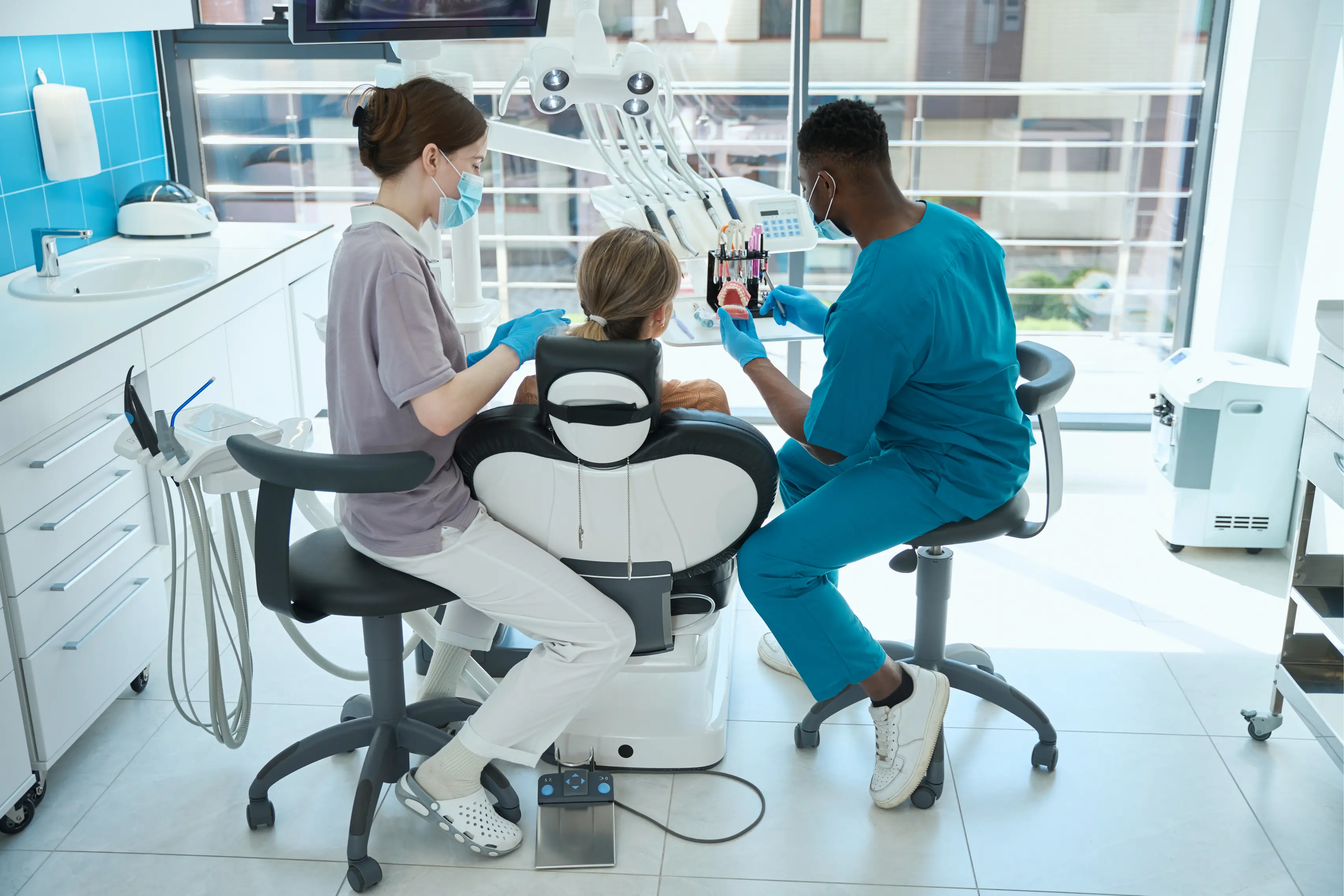 Team of dentists treating a young child patient in a clean, modern dental clinic emphasizing gentle pediatric care and a positive first dental experience