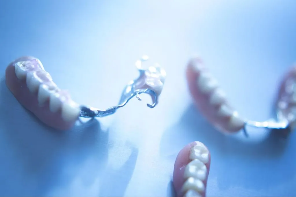 Set of multiple partial dentures arranged on a clean background highlighting various styles of removable dental prosthetics for restoring missing teeth