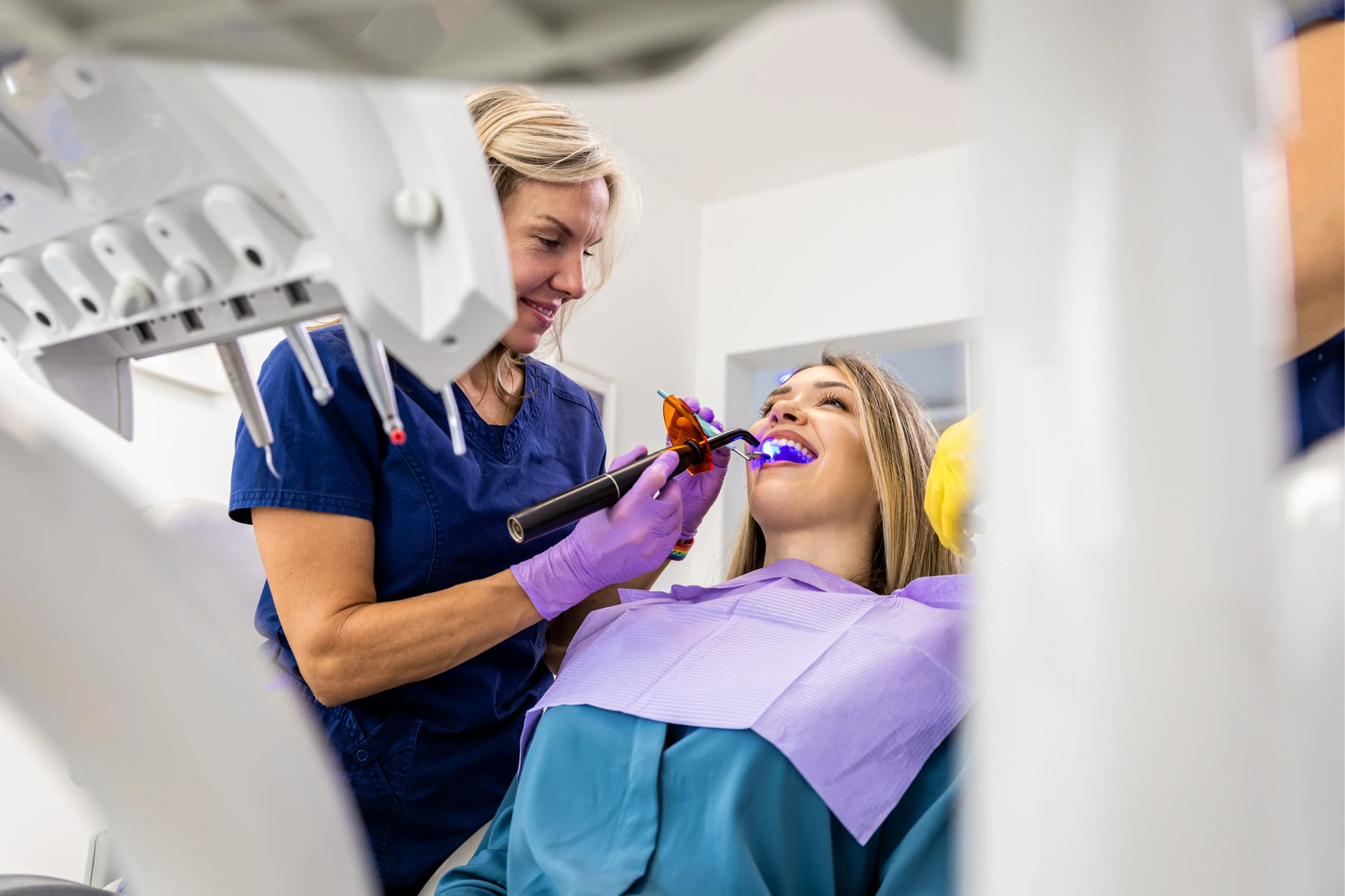 Dentist and dental assistant working together to perform a restorative dental procedure on a patient in a fully equipped clinic showcasing teamwork and modern dental technology