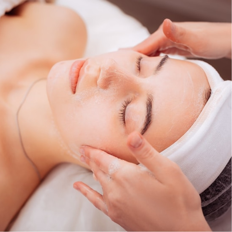 Person receiving a facial treatment with creamy mask and gentle hand massage.