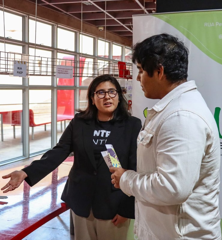 Estudiante colaborador de la Oficina de Iniciativas Estudiantiles orienta a un estudiante sobre su proyecto.