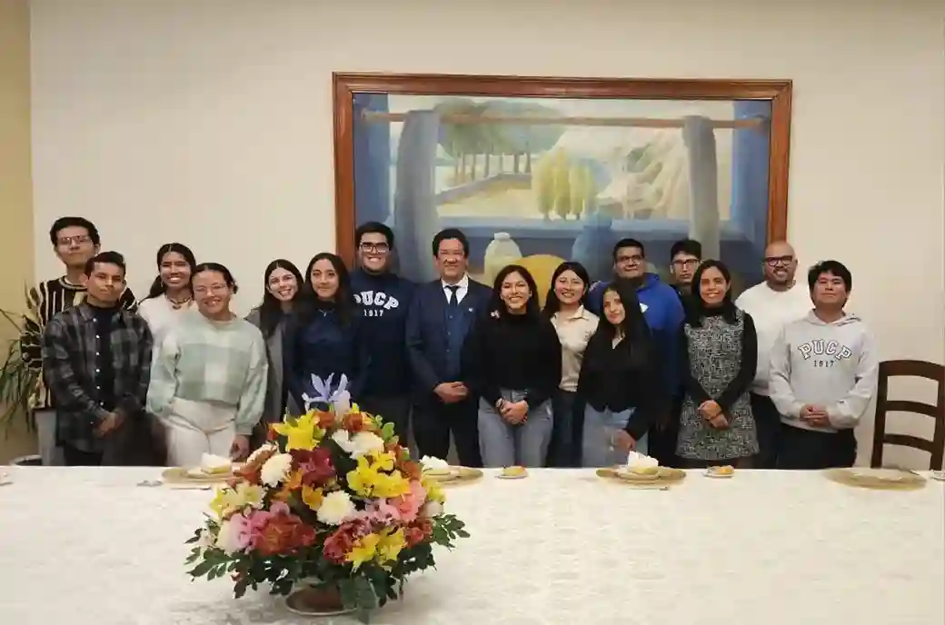 Autoridades universitarias y representantes estudiantiles comparten un almuerzo de confraternidad en un ambiente institucional con una mesa decorada con flores