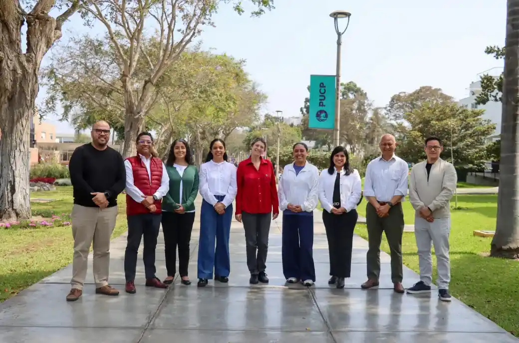 Grupo de personas posando en un campus universitario durante un encuentro institucional.