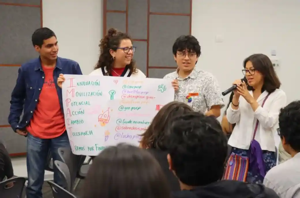 Estudiantes presentando un cartel durante un encuentro de Iniciativas Estudiantiles.