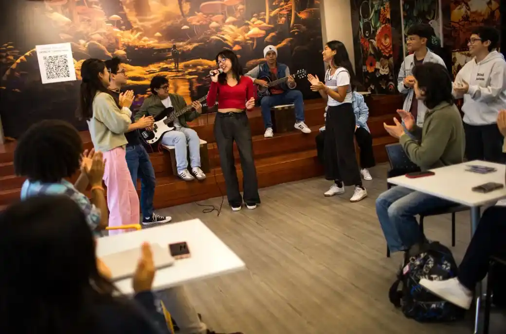 Estudiantes participando en una dinámica artística en un espacio de trabajo colaborativo.