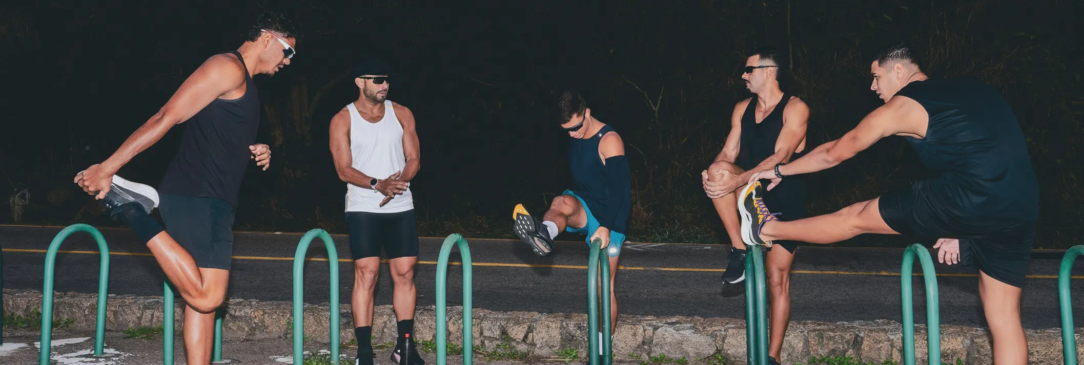 Group of five fit men stretching together before an outdoor night run, symbolizing Gameday’s mission to empower men’s health, vitality, and overall performance.