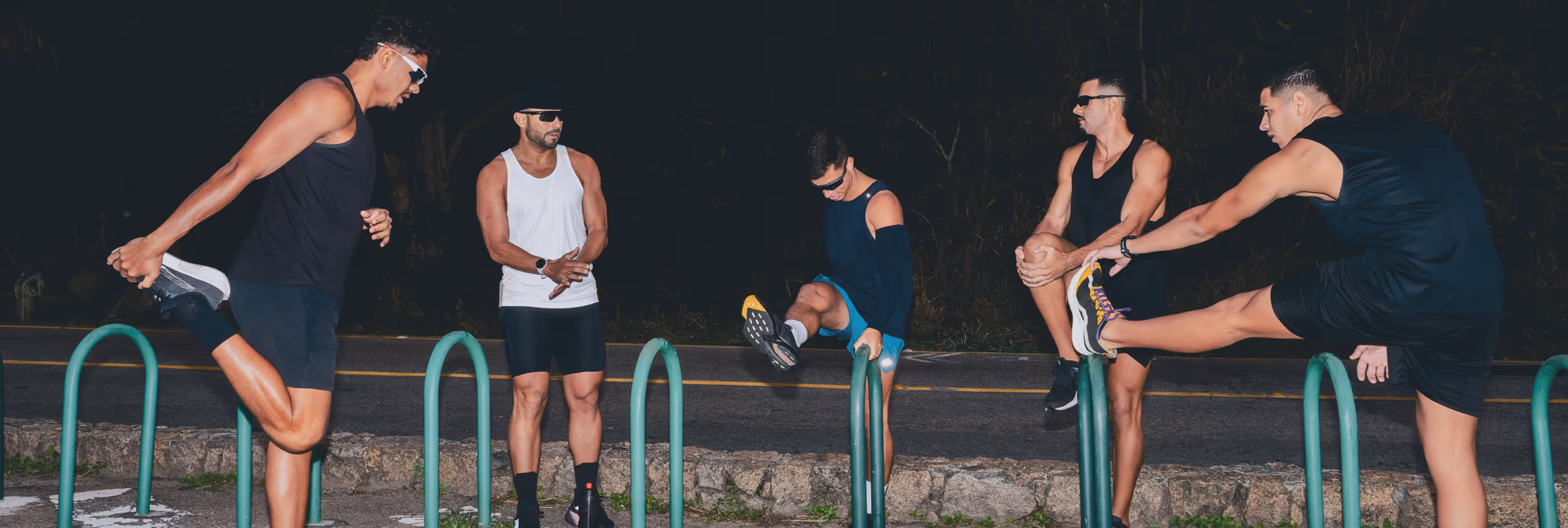 Group of five fit men stretching together before an outdoor night run, symbolizing Gameday’s mission to empower men’s health, vitality, and overall performance.