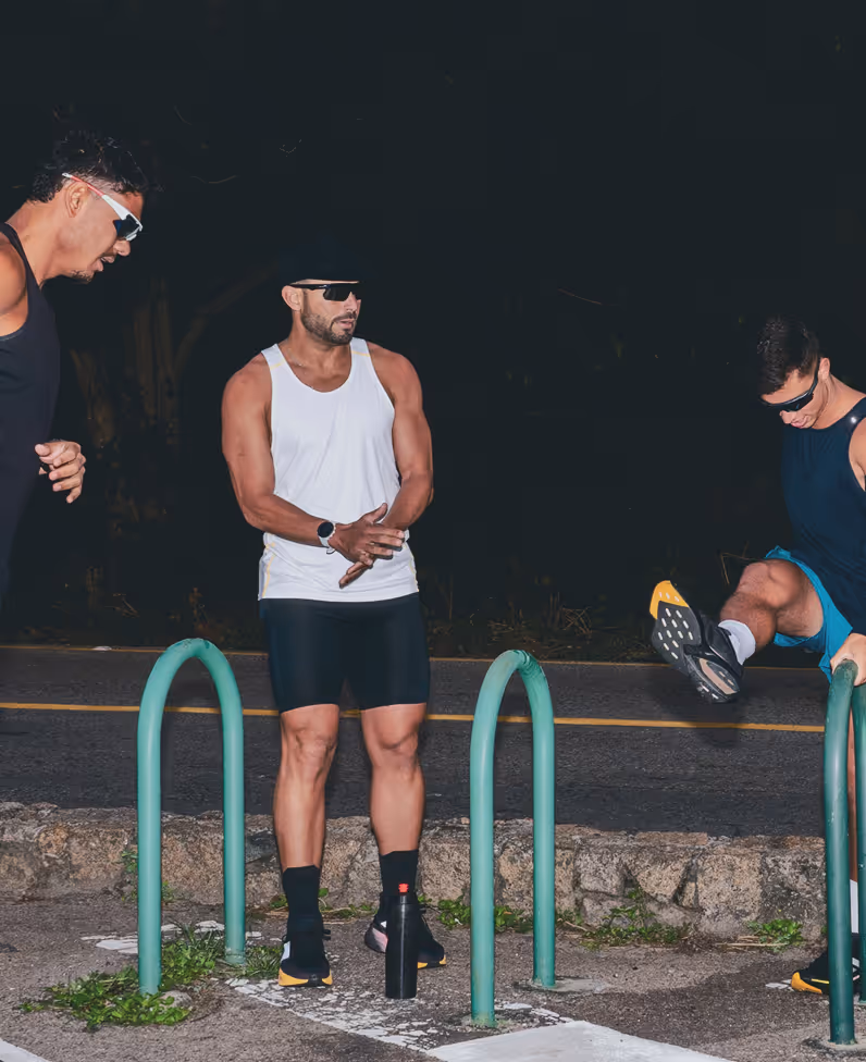 Group of five fit men stretching together before an outdoor night run, symbolizing Gameday’s mission to empower men’s health, vitality, and overall performance.