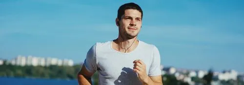 Man running near water with earphones in, reflecting boosted stamina and metabolism support from B vitamin therapy.