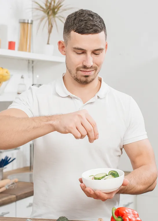 Man preparing a healthy meal in a bright kitchen, representing wellness, detoxification, and healthy lifestyle supported by Glutathione injections.
