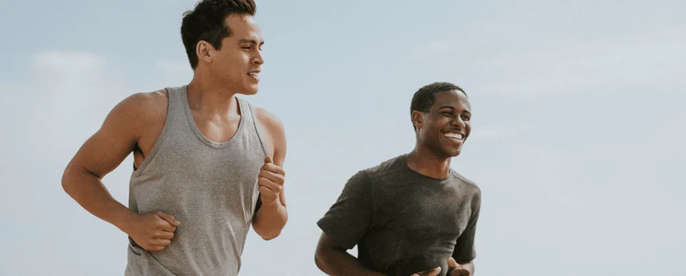 Two men jogging outdoors and smiling, representing increased energy and active lifestyle supported by MIC lipotropic injections