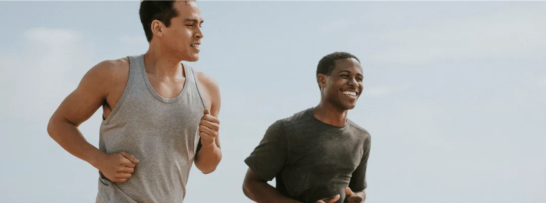 Two men jogging outdoors and smiling, representing increased energy and active lifestyle supported by MIC lipotropic injections .