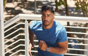 Focused man running up stairs in athletic gear, representing enhanced stamina and physical performance from Vitamin B12 Injections for men.