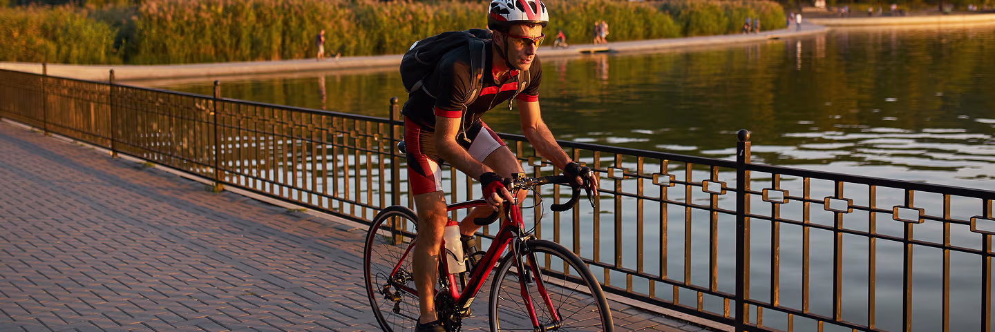 Man cycling by the lake, feeling energized and revitalized through Vitamin B12 injections for enhanced stamina