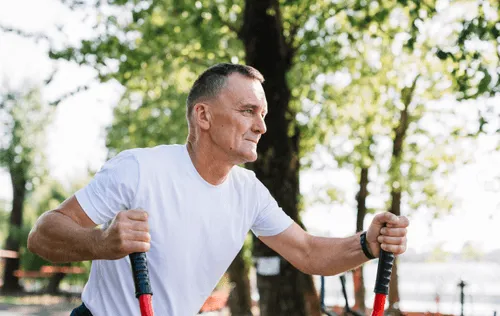 Older man using outdoor exercise equipment, highlighting the endurance, cardiovascular, and nervous system support offered by Vitamin B Complex injections.