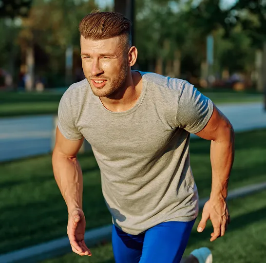 Athletic man sprinting outdoors in activewear, showcasing the energy, endurance, and performance benefits of vitamin injections for men.