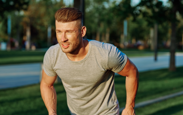 Athletic man sprinting outdoors in activewear, showcasing the energy, endurance, and performance benefits of vitamin injections for men.