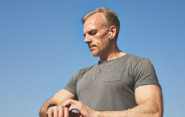 Man checking his smartwatch outdoors after a vitamin injection session